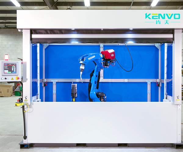 A robot working inside an enclosed station behind a blue process screen.