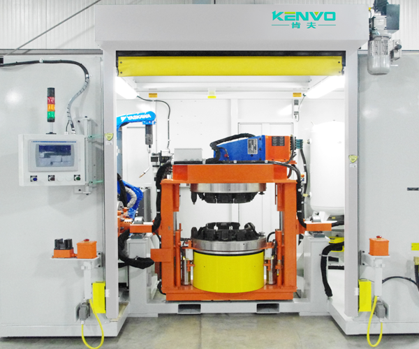 A photographed enclosed cell with robot tooling and an overhead rolling-door assembly.